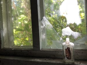 a bottle of perfume on a window sill
