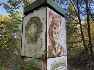 a rusty sign with a picture of a man and a man