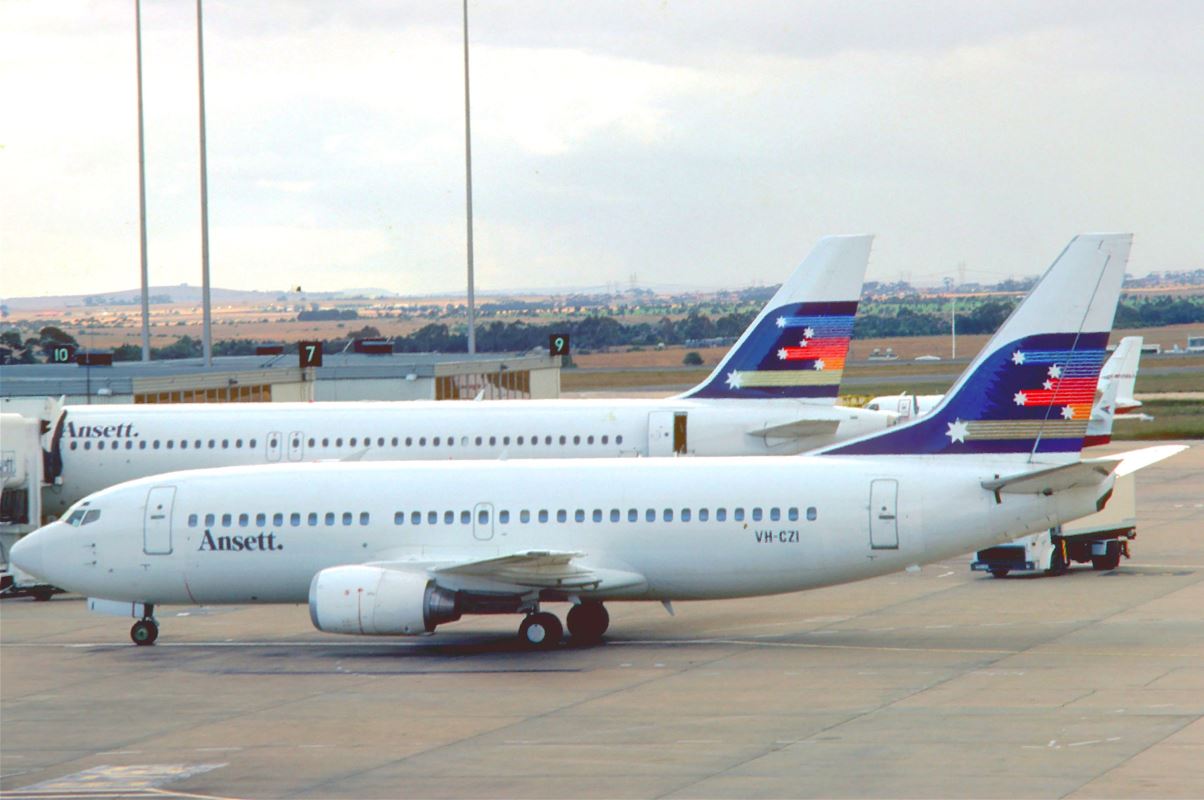 two airplanes parked at an airport