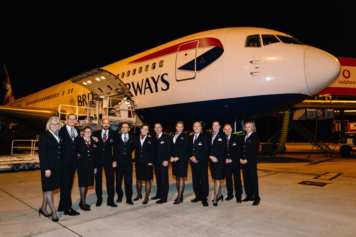 a group of people in uniform standing in front of an airplane