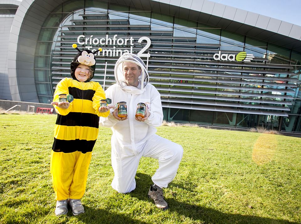 a man and child in bee clothing holding jars