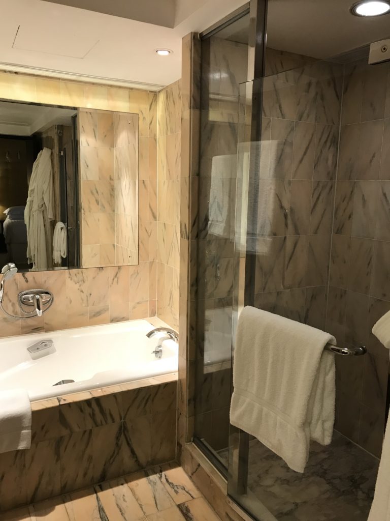 a bathroom with a glass shower door and bathtub