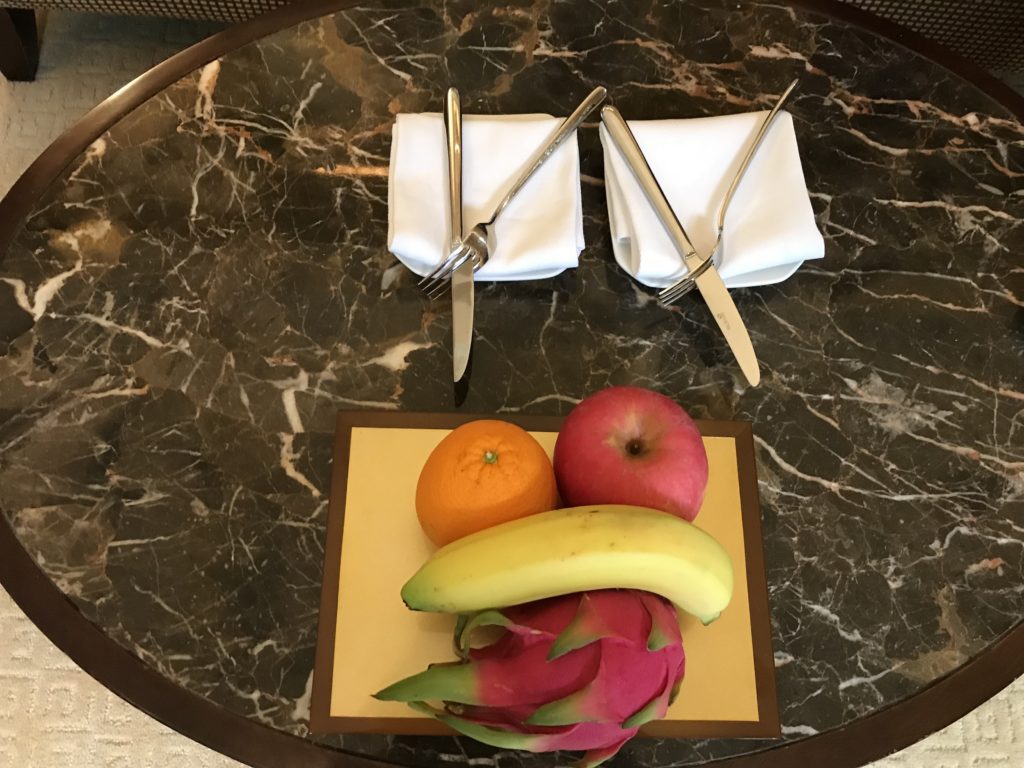 a plate with fruits on it and silverware on a table