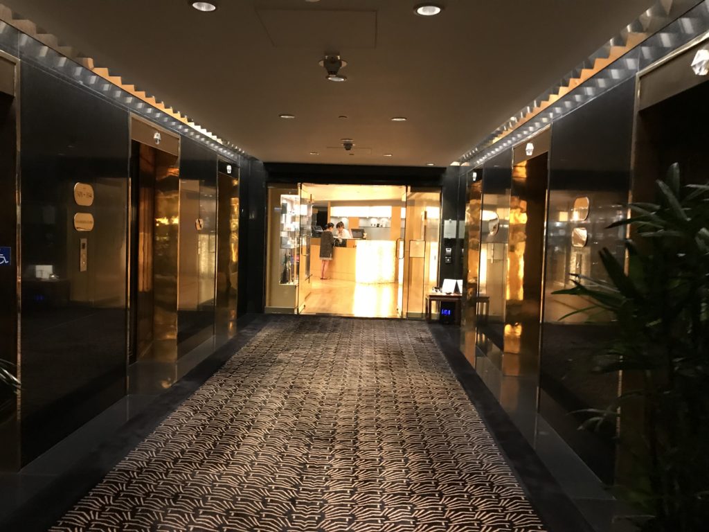 a hallway with elevators and plants