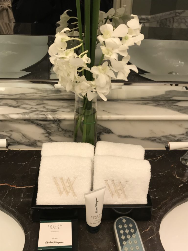 a white towels and a vase of flowers