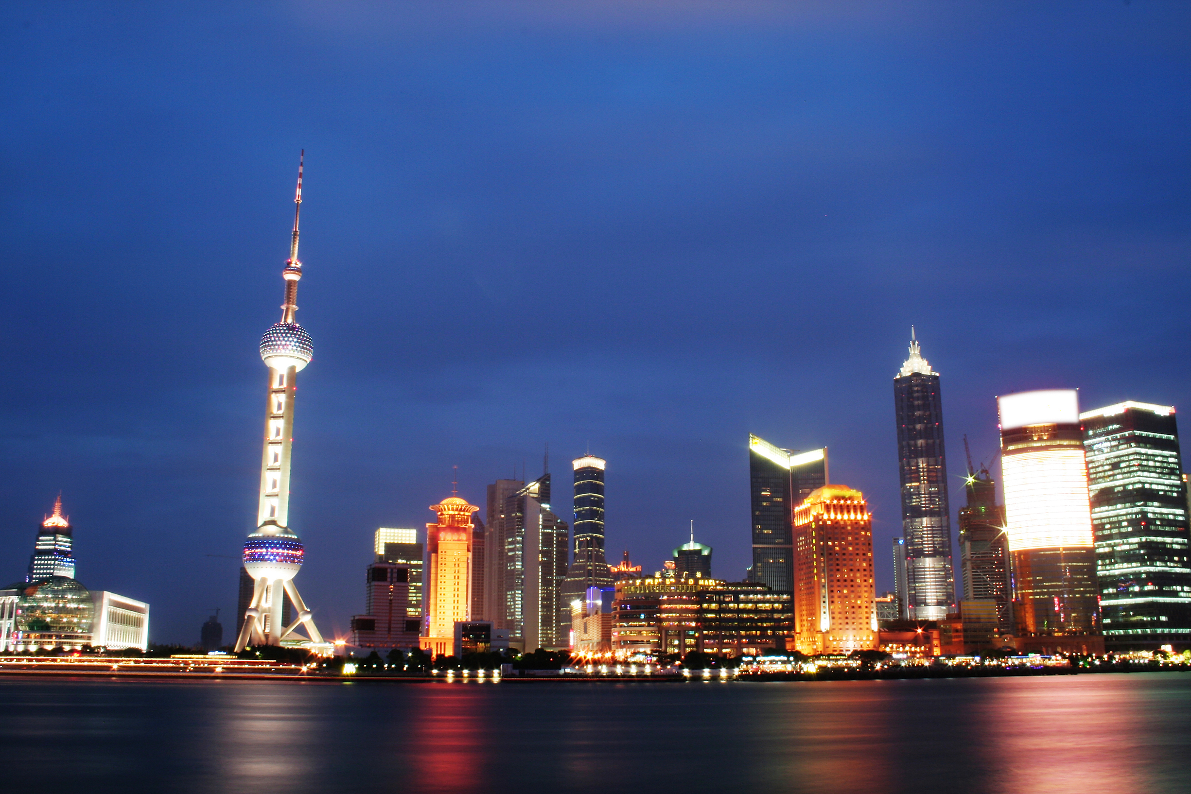 a city skyline with lights and a body of water