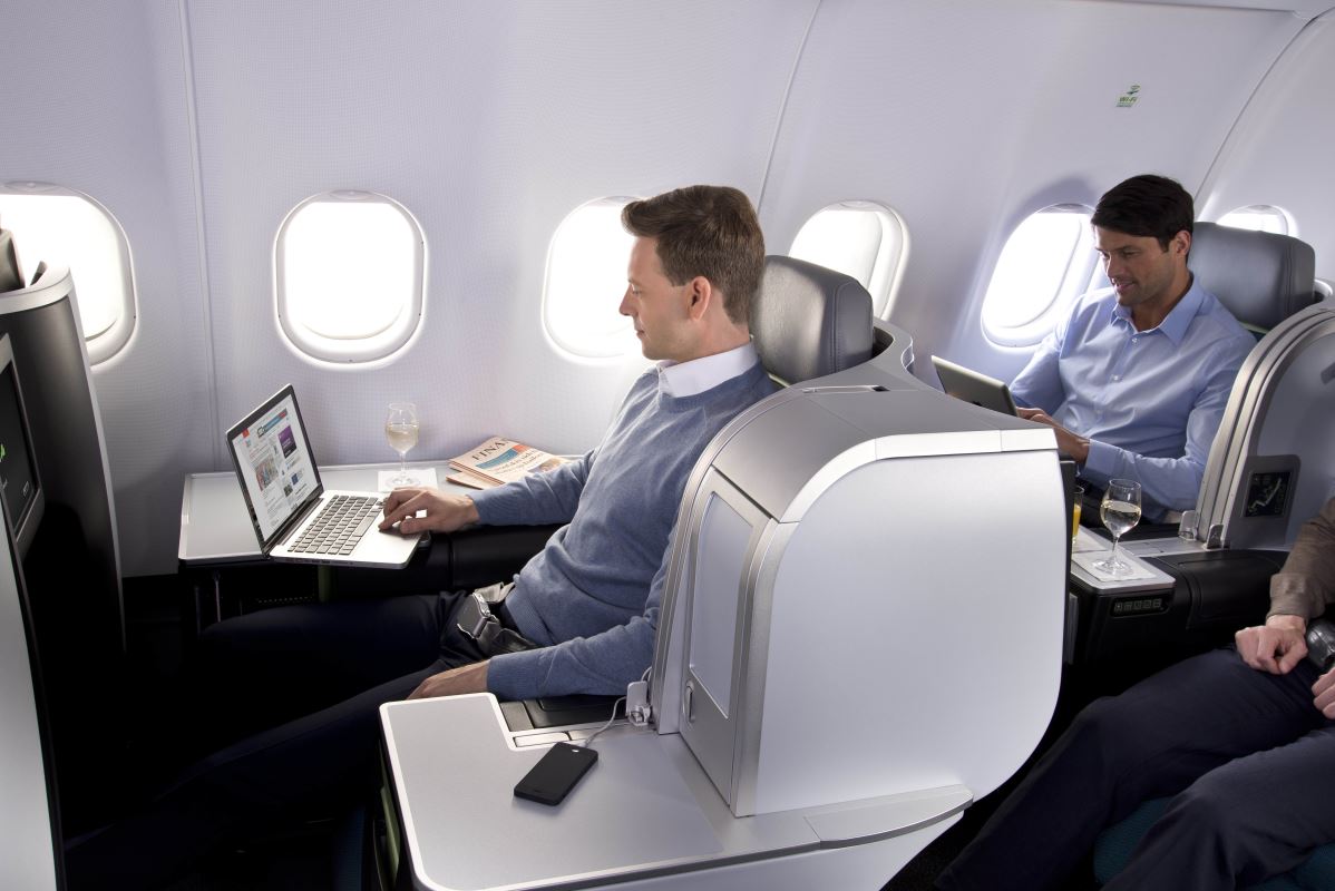 a man using a laptop on an airplane