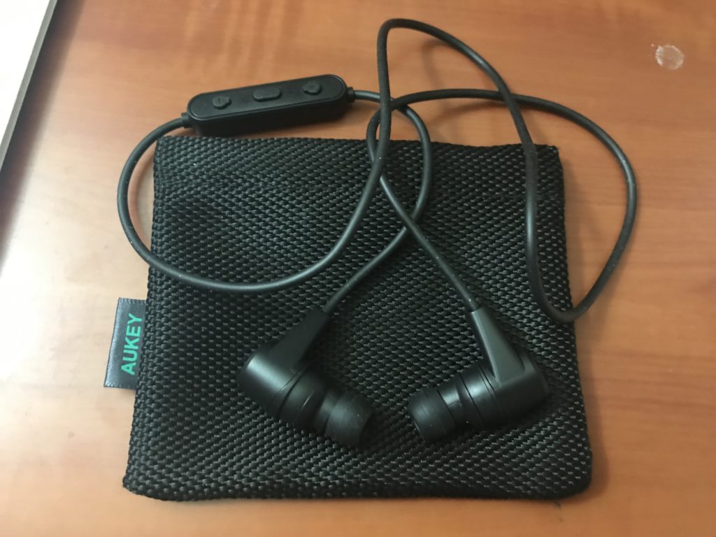 a pair of black earbuds on a black cloth