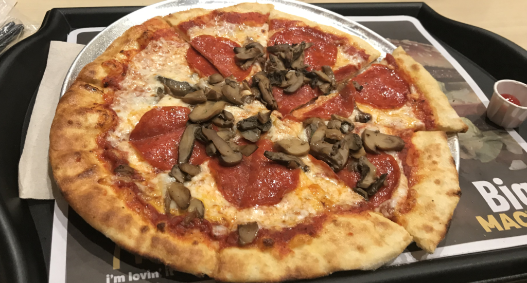 a pizza with mushrooms on a pan