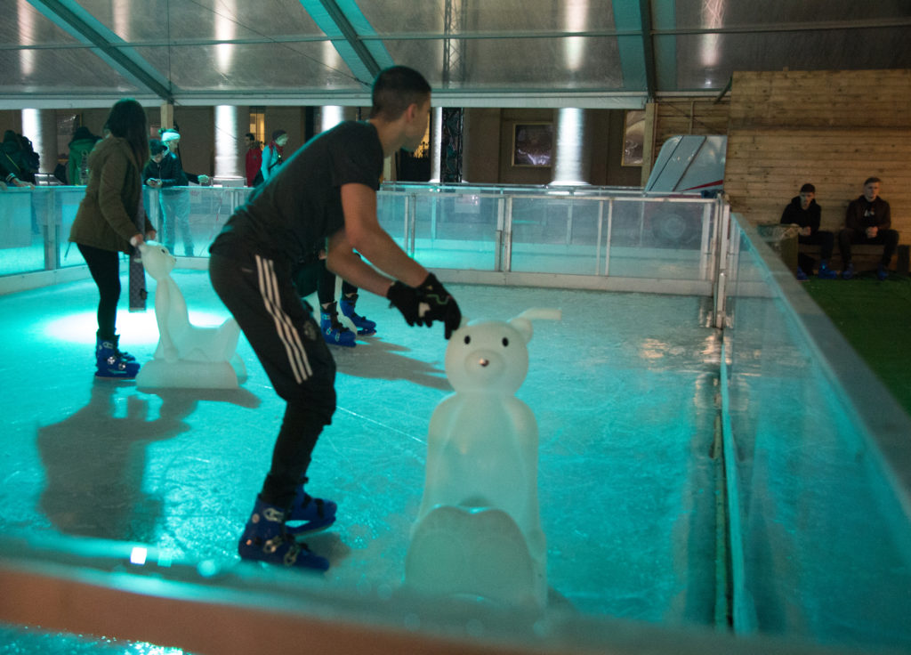 a man on ice skating with a bear