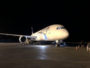 a white airplane on a runway at night