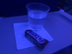 a glass of water and a candy bar on a table