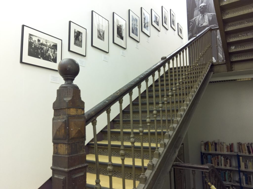 a staircase with a railing and a wall of pictures