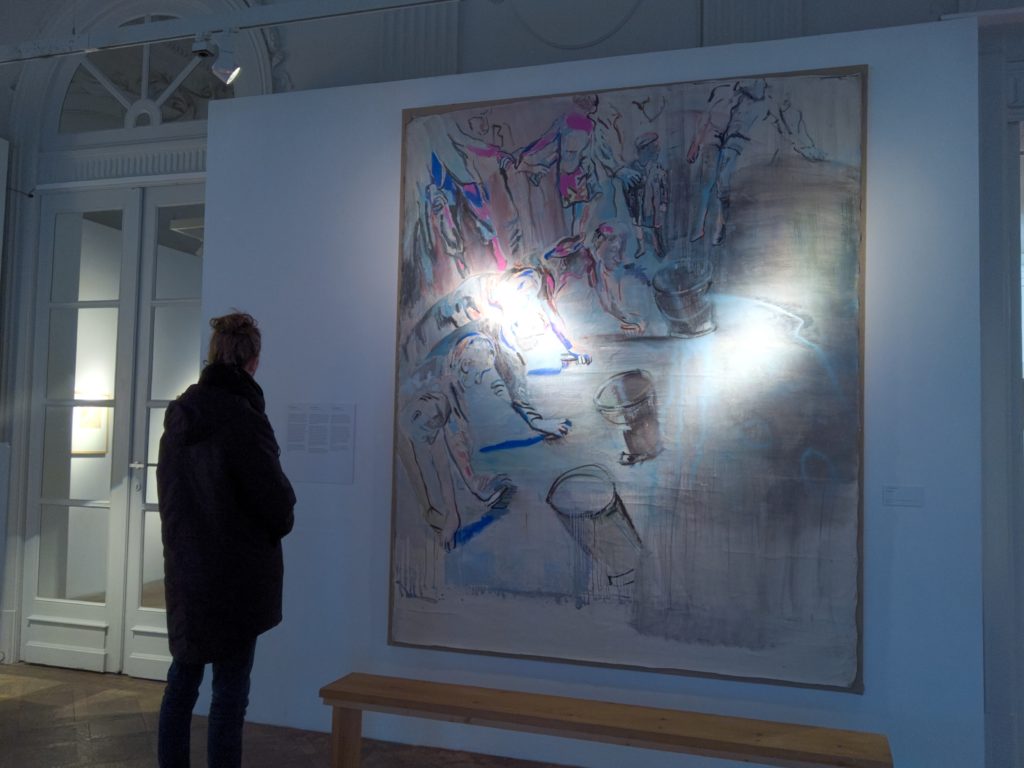 a woman looking at a painting on a wall