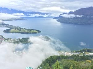 a body of water with clouds and mountains