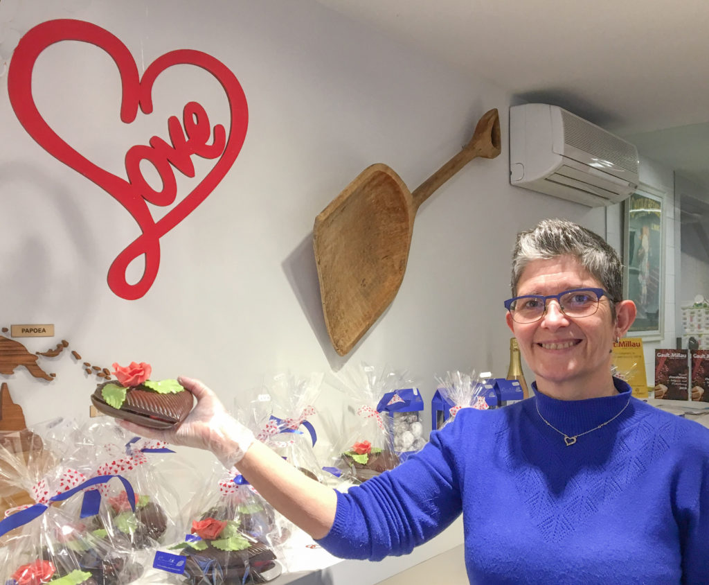 a woman holding a chocolate cake