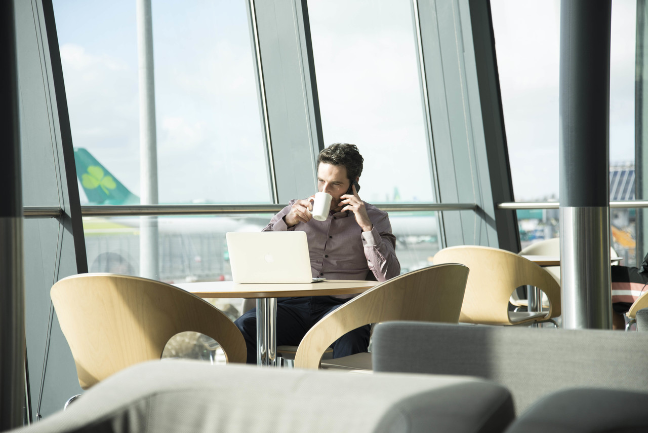 a man sitting at a table with a laptop and phone