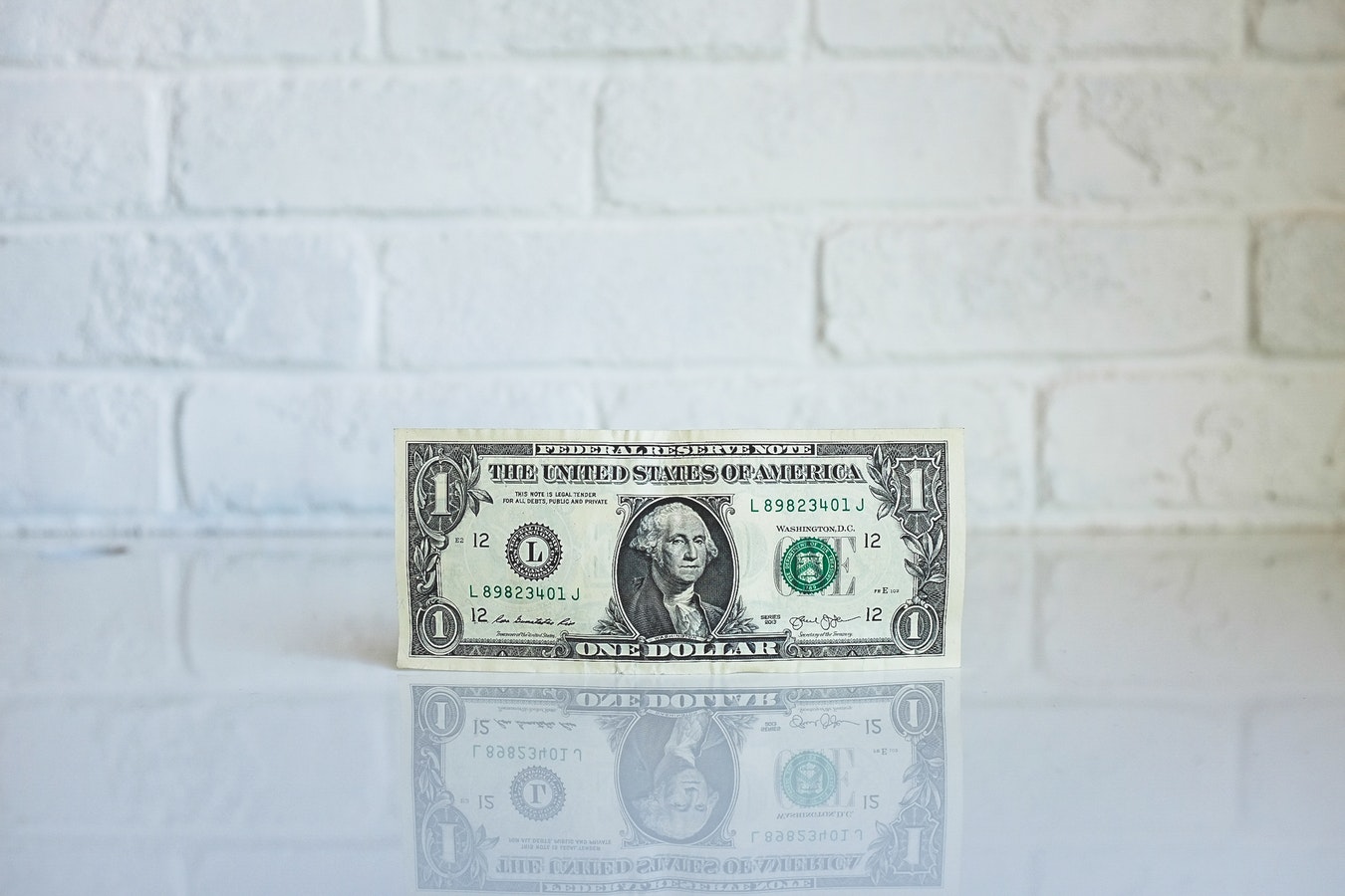 a one dollar bill on a white surface