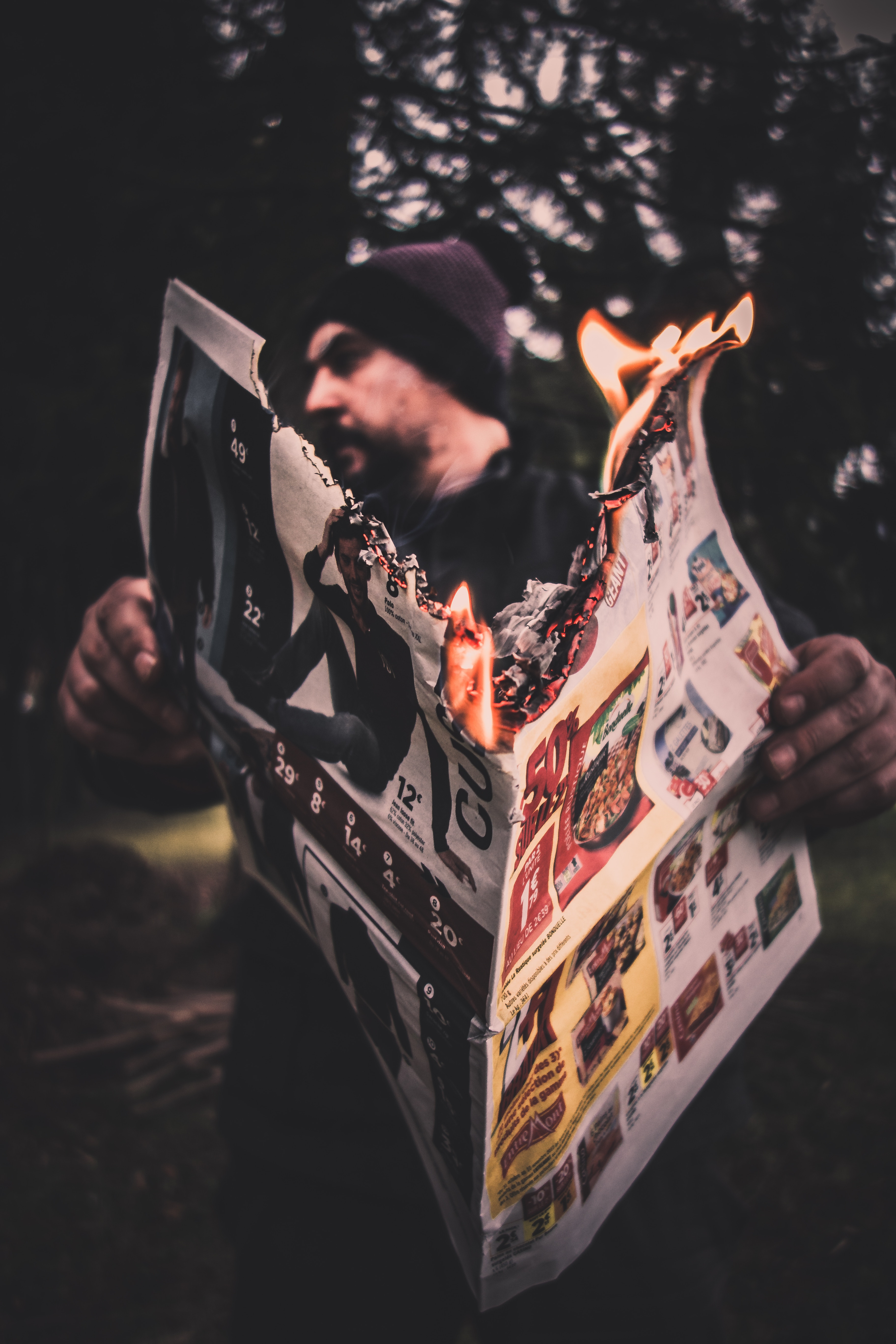 a man holding a newspaper with a burning paper