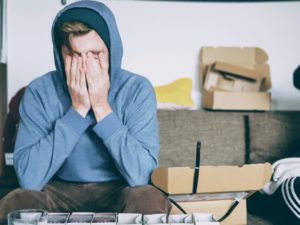 a man sitting on a couch with his hands in his face