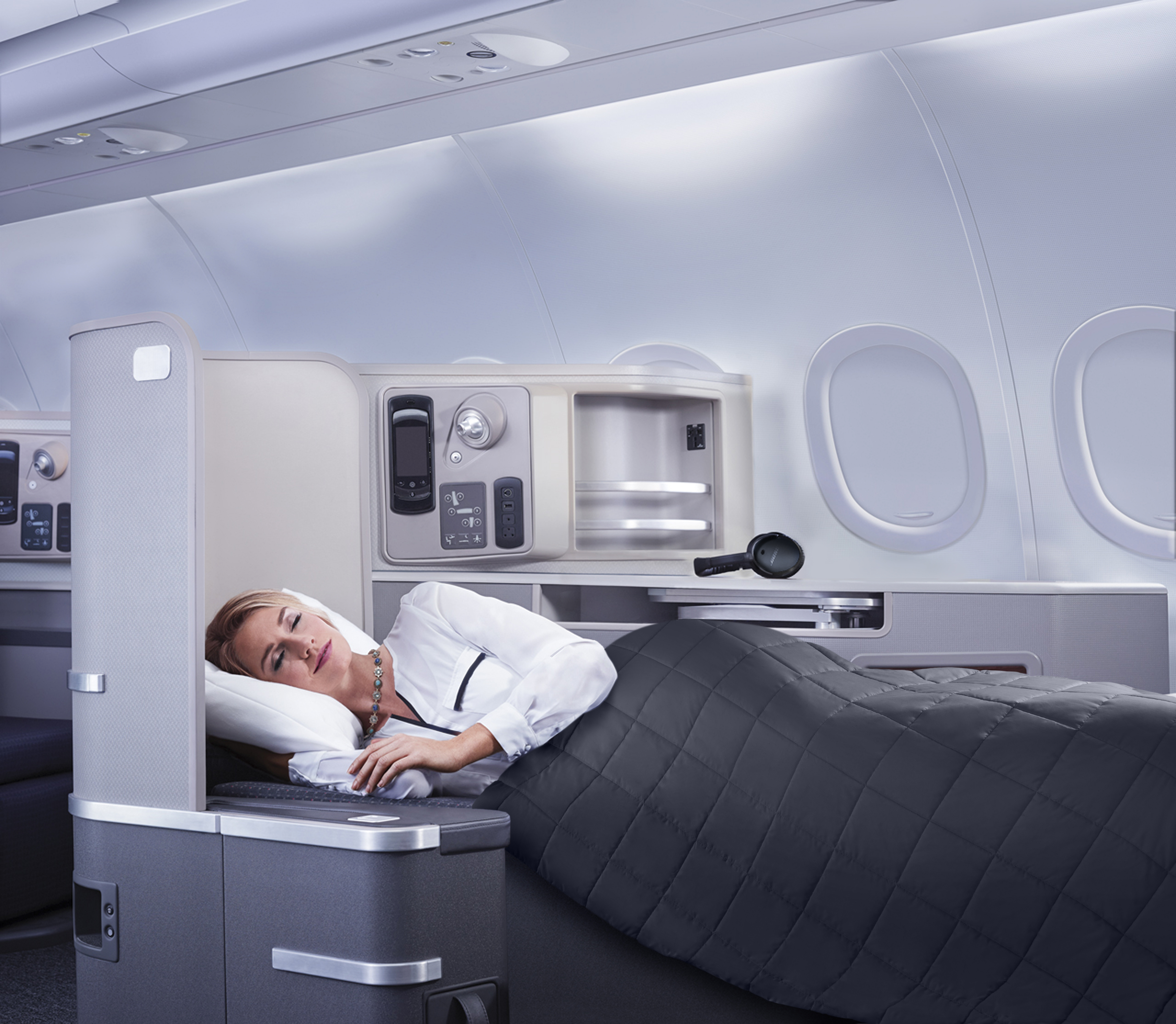 a woman lying in a bed in an airplane