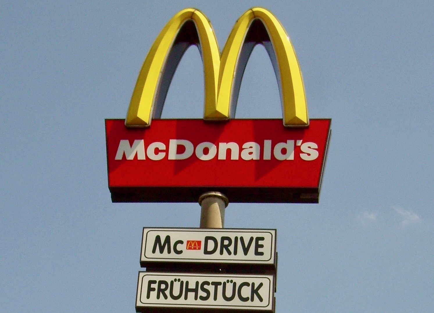 a sign post with a red and yellow logo