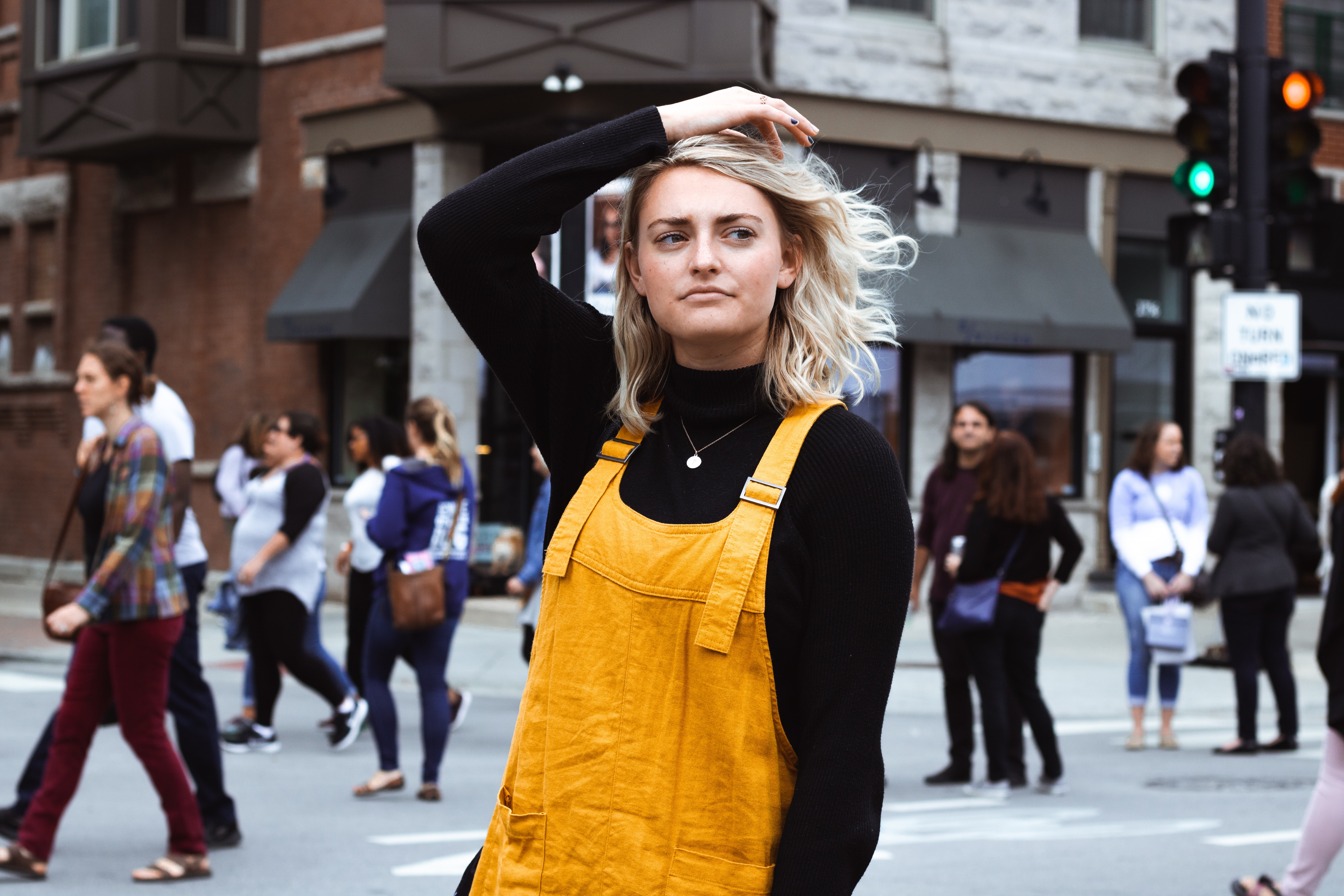 a woman in yellow overalls posing for a picture