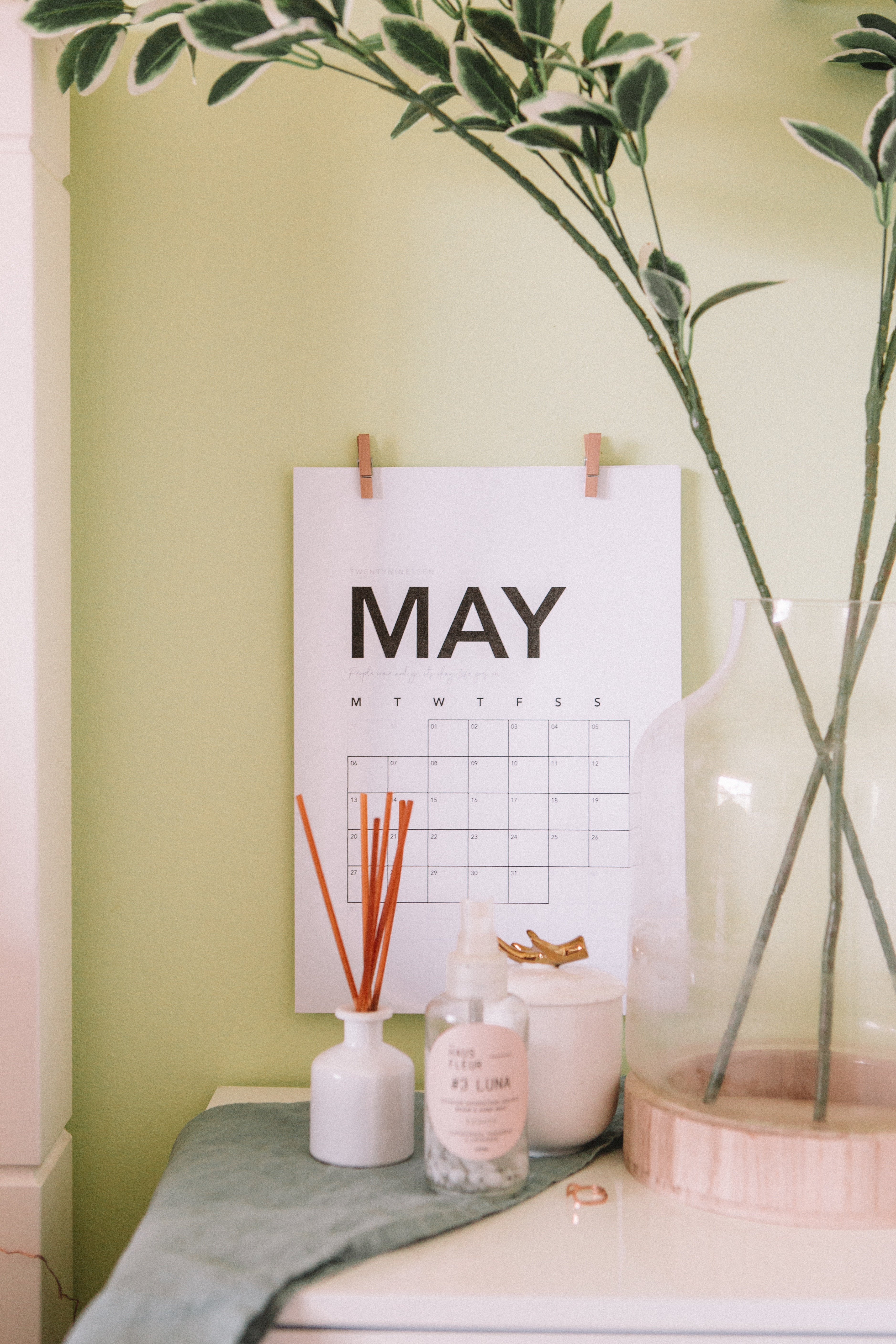 a calendar with a plant and a glass vase