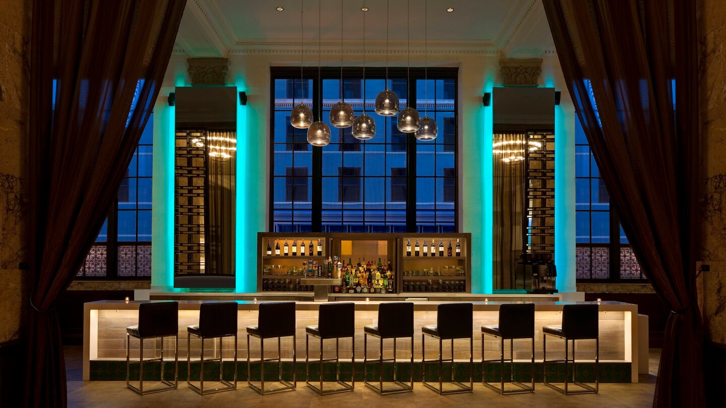 a bar with chairs and a shelf in front of a window