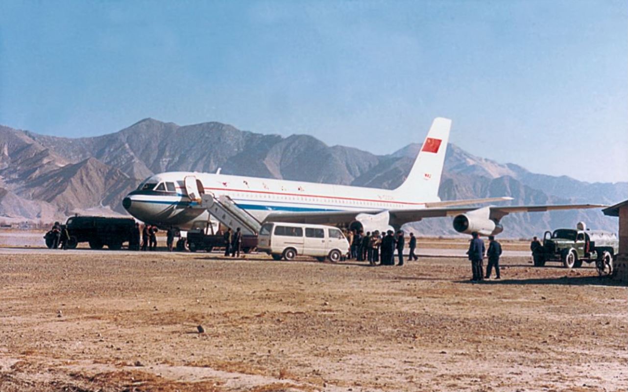 a group of people standing next to an airplane