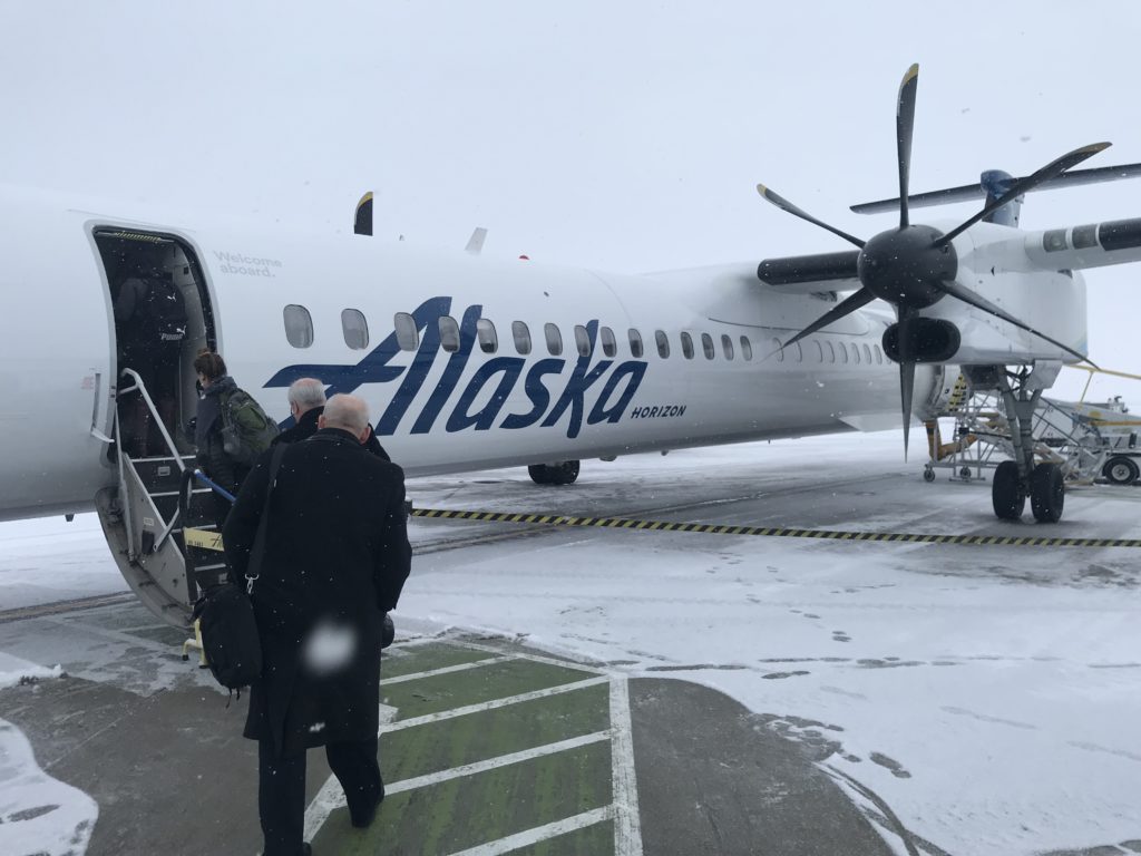 people boarding an airplane in the snow