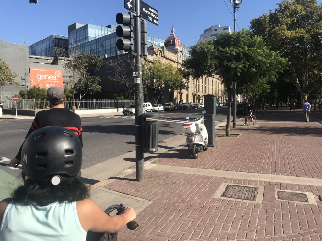 a person on a scooter on a sidewalk