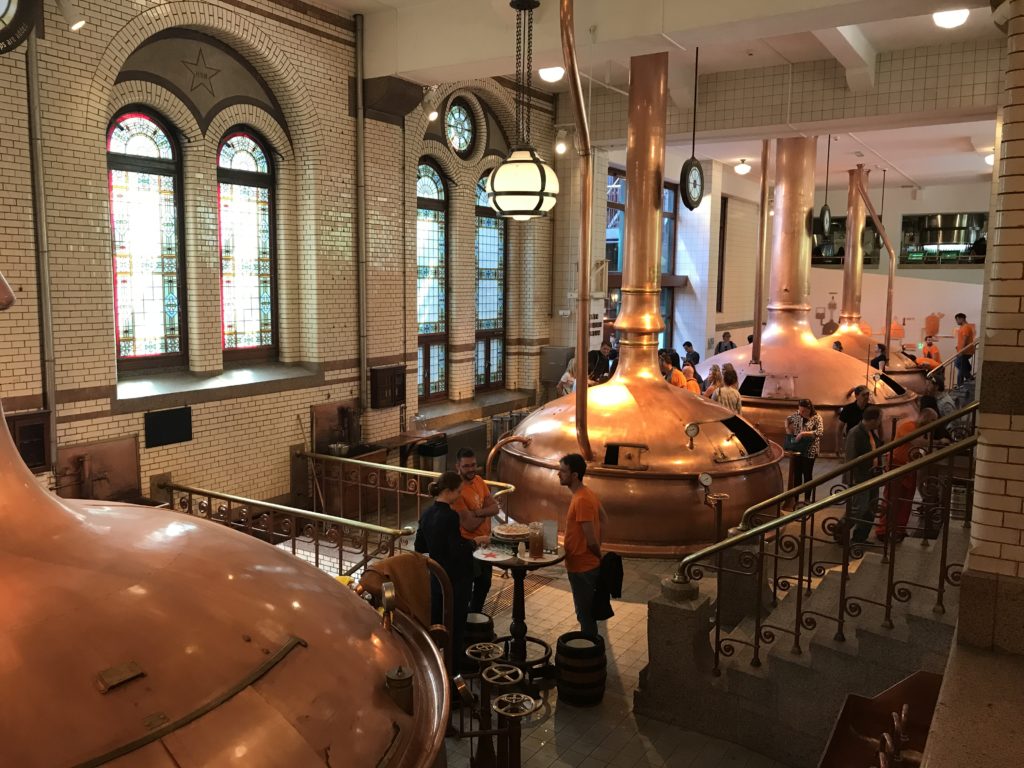 a large room with large copper tanks and large windows