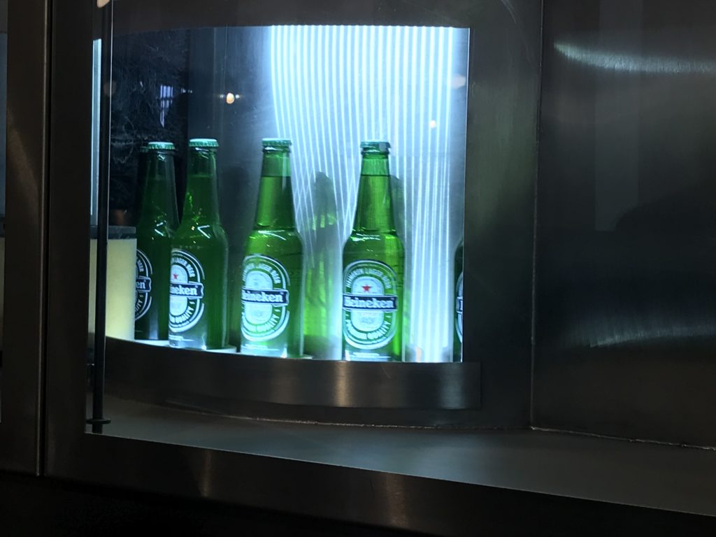 a row of green bottles in a glass case