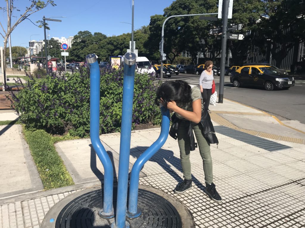 a woman looking at a blue pipe