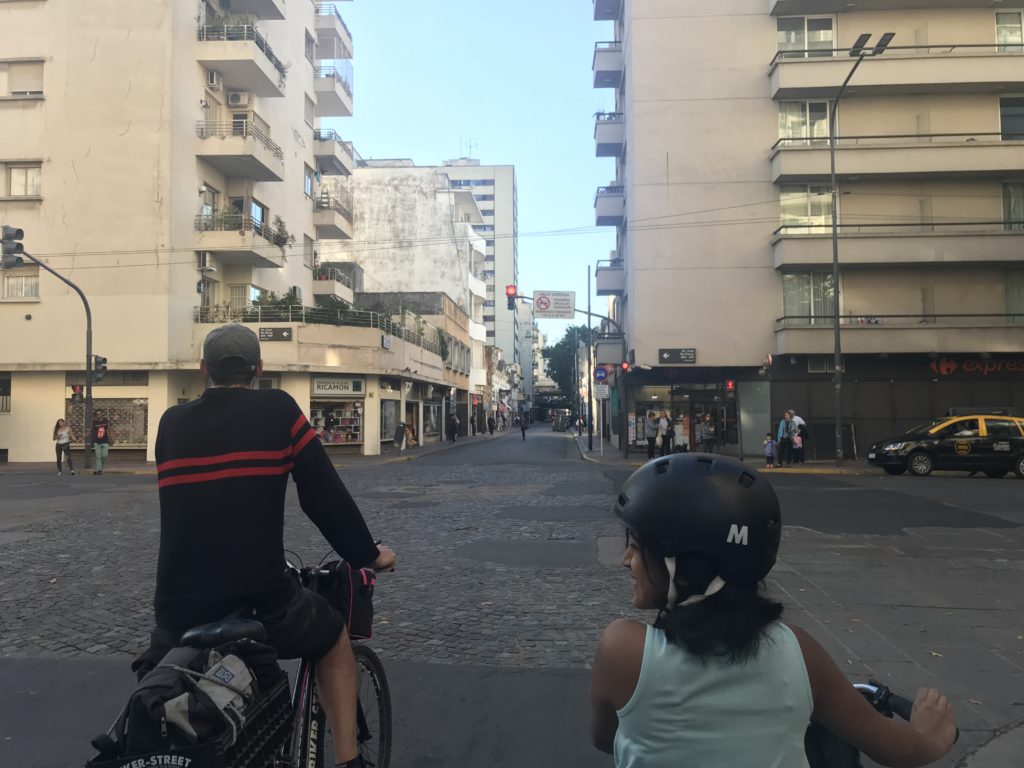a man and woman riding bikes on a street
