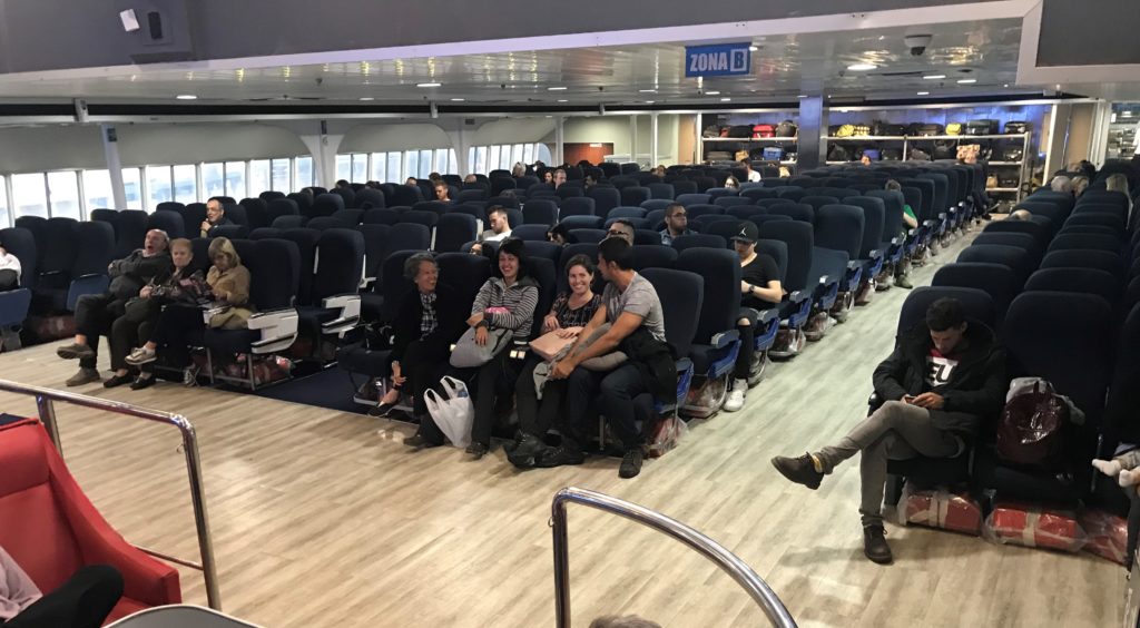 a group of people sitting in chairs in a room with a person standing