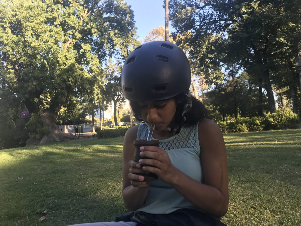 a woman wearing a helmet and drinking from a cup