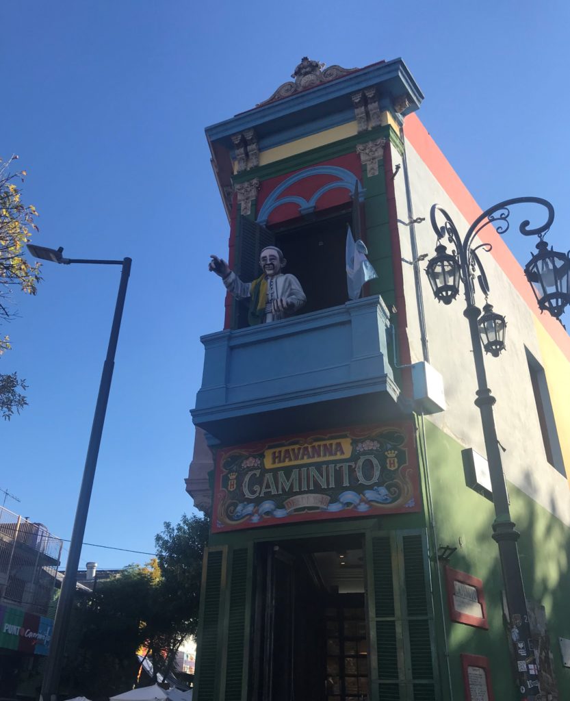 a building with a statue on the balcony