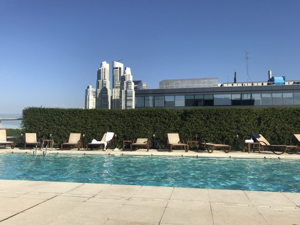 a pool with lounge chairs and a building in the background
