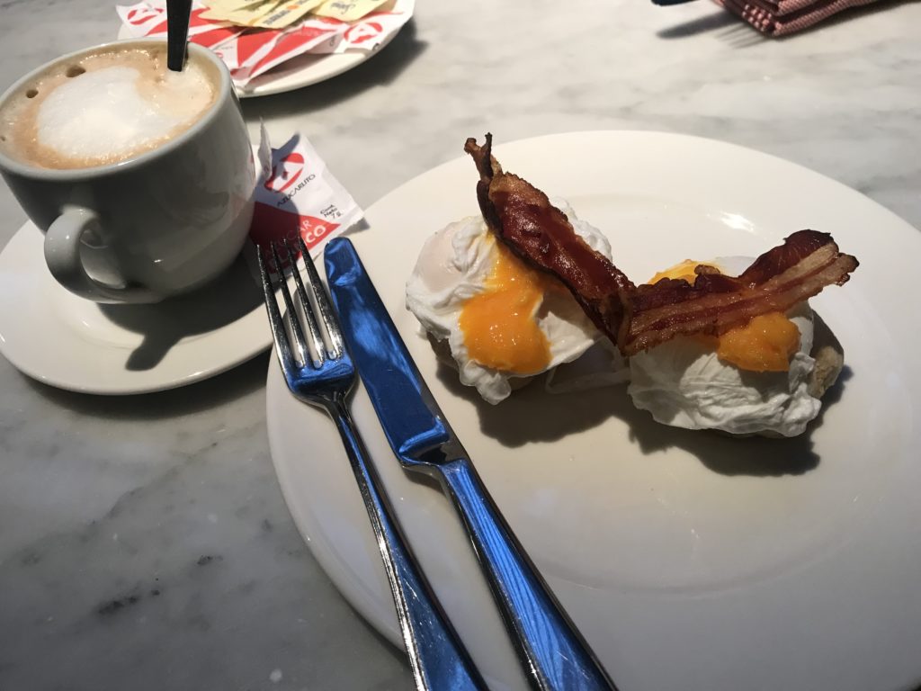 a plate with eggs benedict and bacon on it