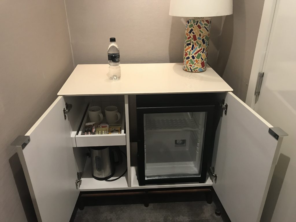 a small refrigerator with a lamp and a bottle on top