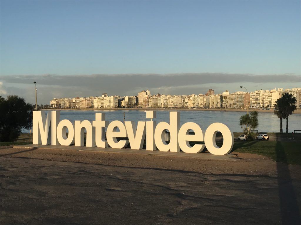 a large white sign with a city in the background