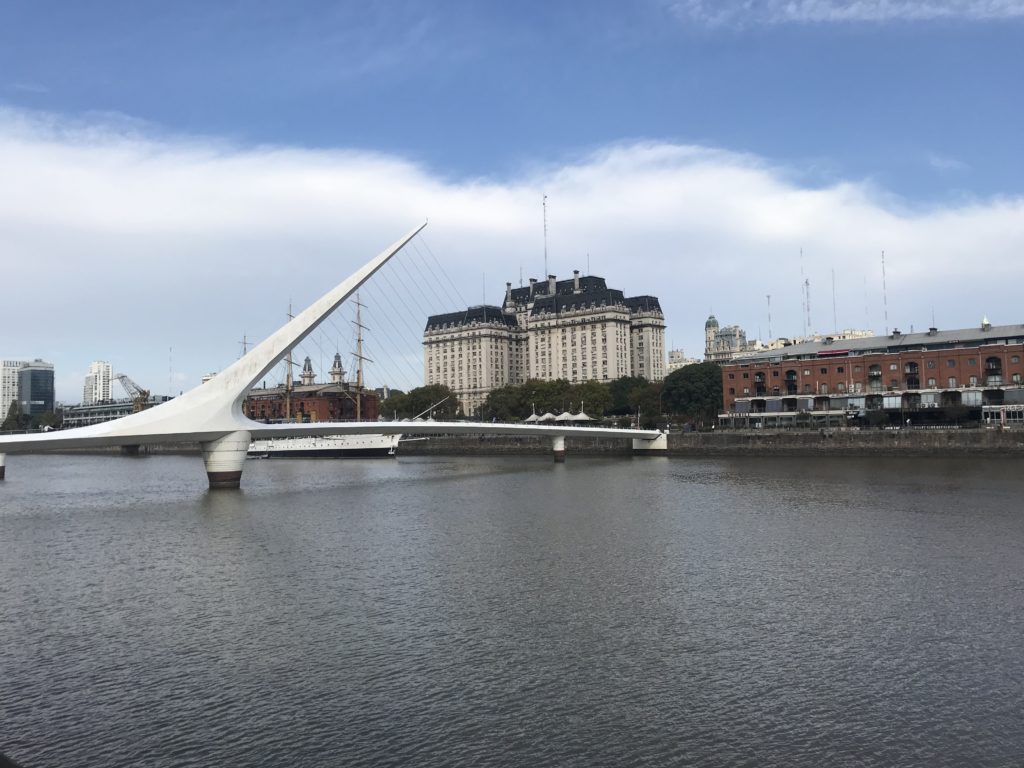 a bridge over a body of water with buildings in the background
