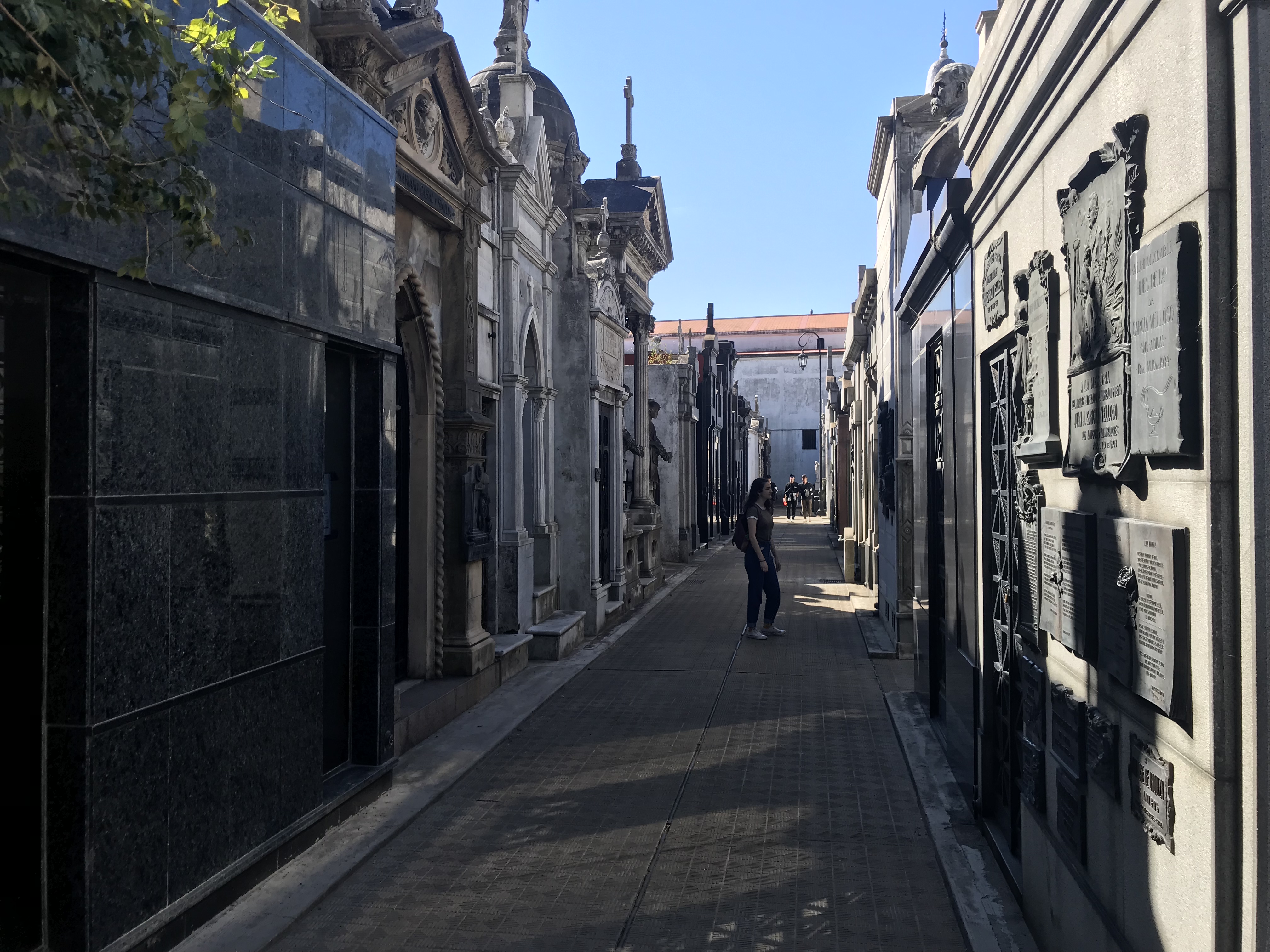 a person standing on a narrow street between buildings