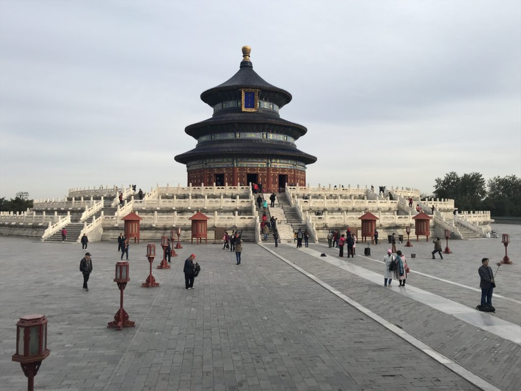 a circular building with a circular roof and stairs leading to it with Temple of Heaven in the background