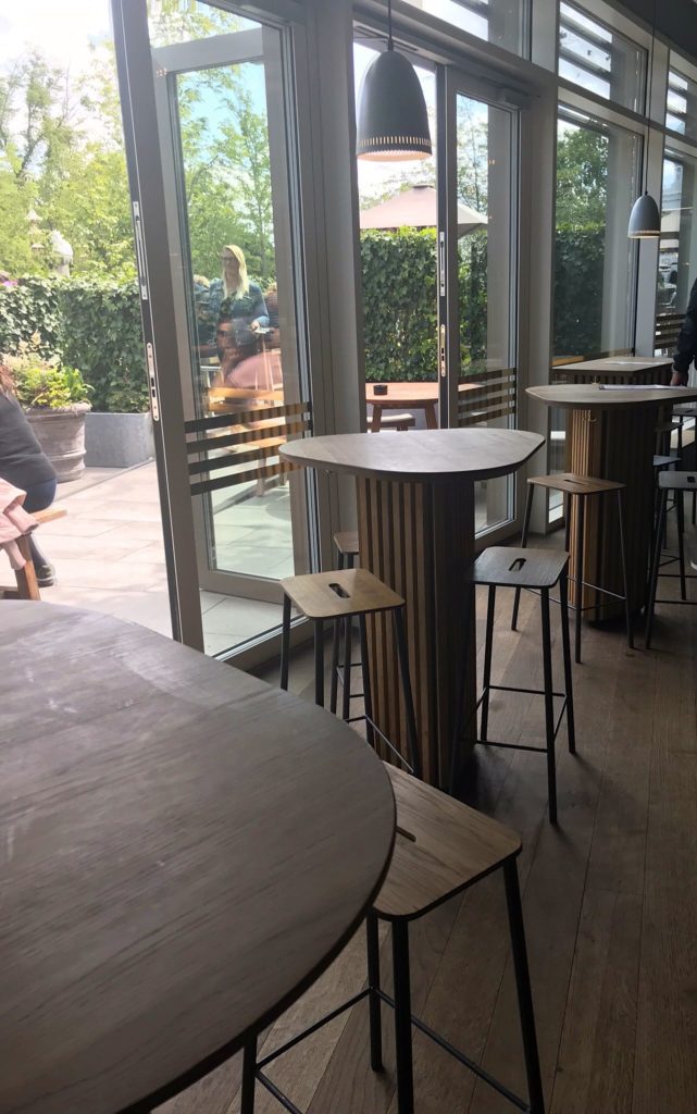 a table and stools in a room with glass doors
