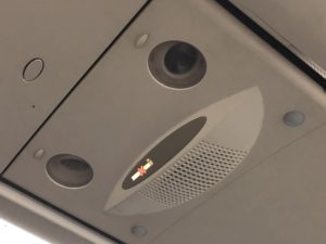 a speaker and a sign on the ceiling of a plane