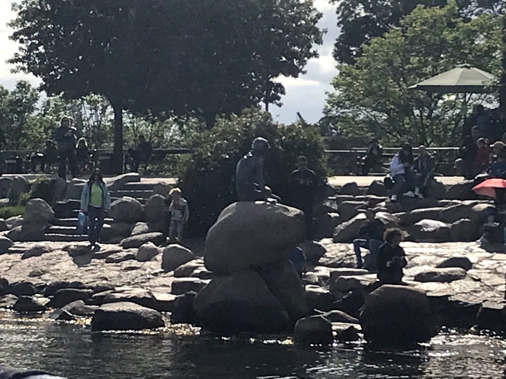 a group of people sitting on rocks by water