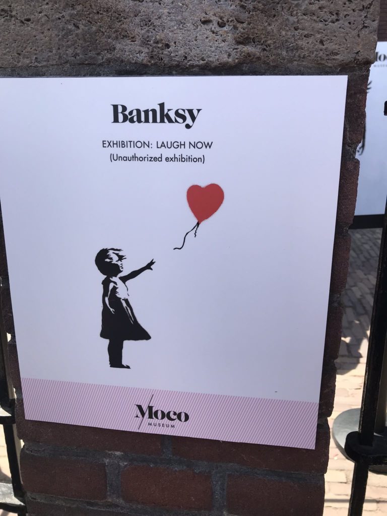 a sign with a balloon and a girl